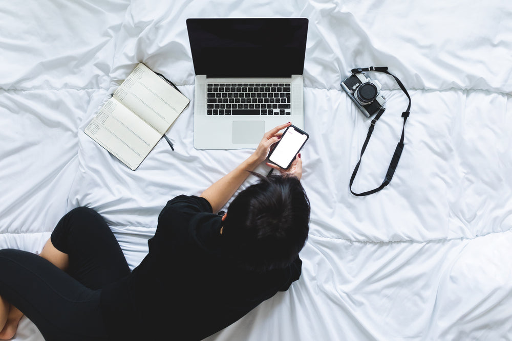 person lays on bed with a laptop on front of them