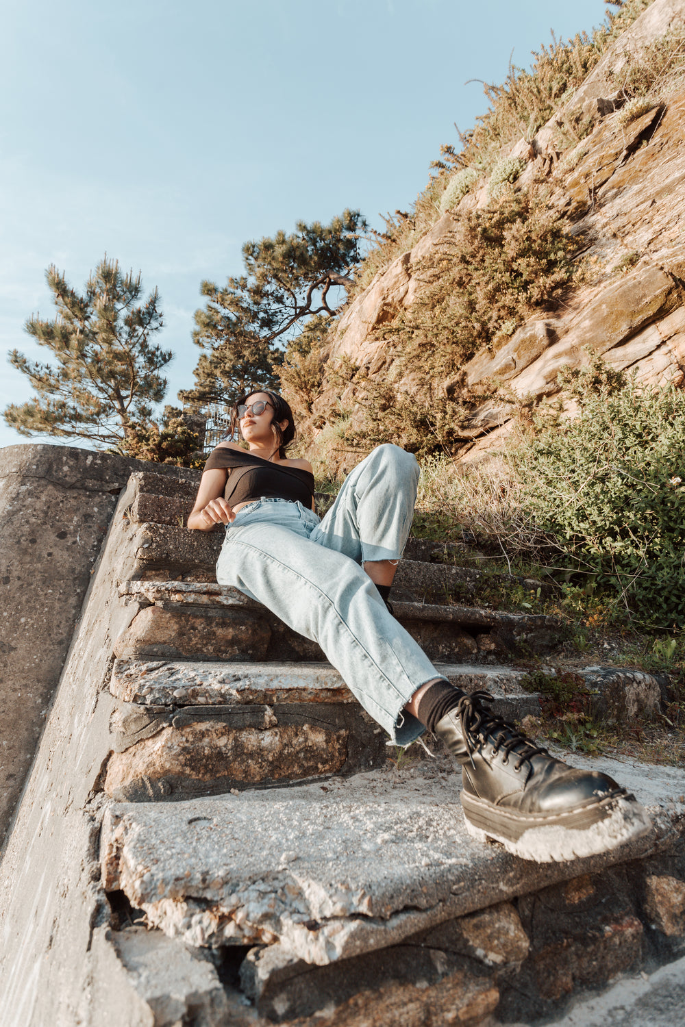 person leans back on stone steps outdoors