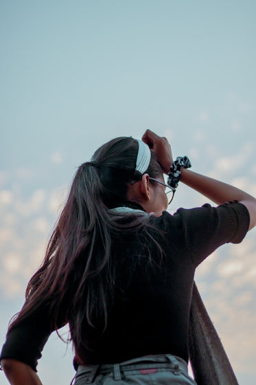 person looking away below a blue sky