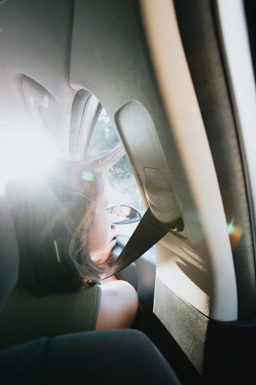 person looking out the front seat window of a car