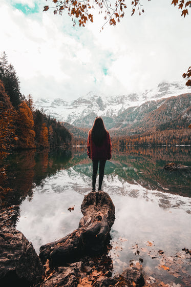 person looks out to an autumn day by a lake