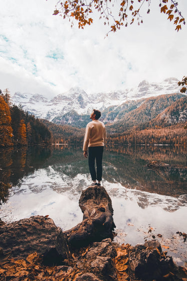 person looks out towards white mountains in the fall