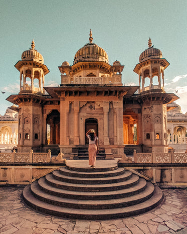 person looks up towards beautiful architecture