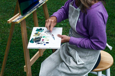 person mixes paint in a pallet with a pallet knife