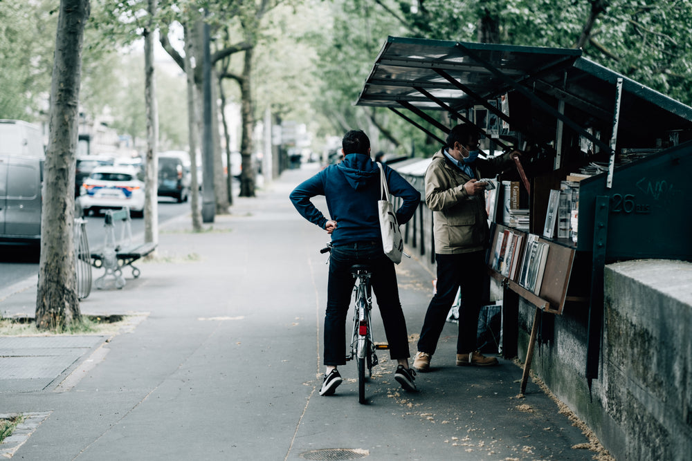 person on a bike waits for their friend to shop for books