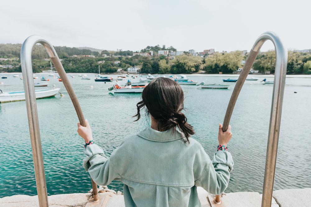 person outdoors looks out at boats below