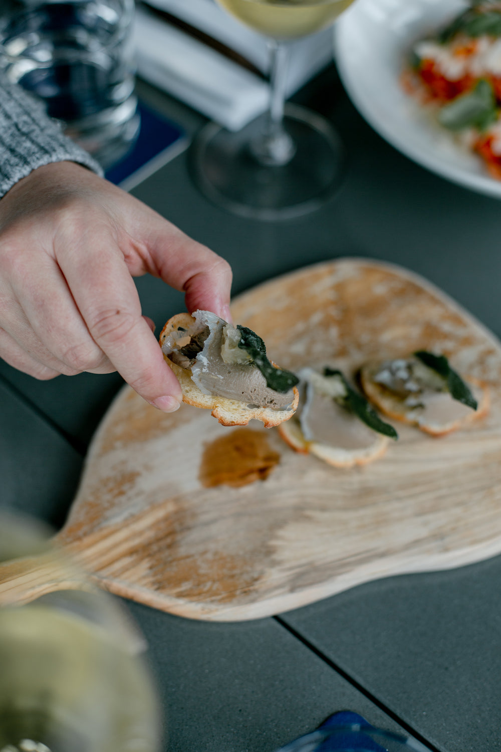 person picks up a crostini appetizer