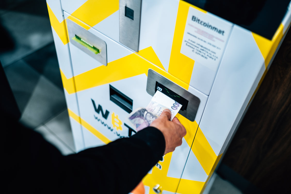 person places cash into a yellow and white machine