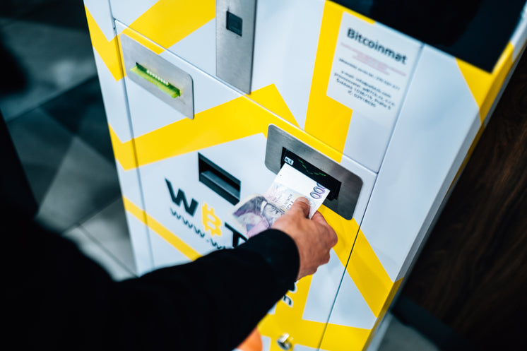 Person Places Cash Into A Yellow And White Machine