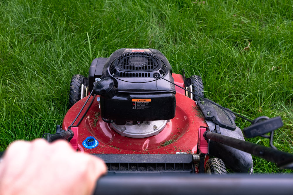 person pushing lawn mower