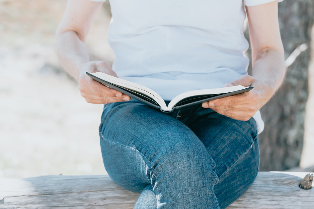 person reading with the book open on their lap