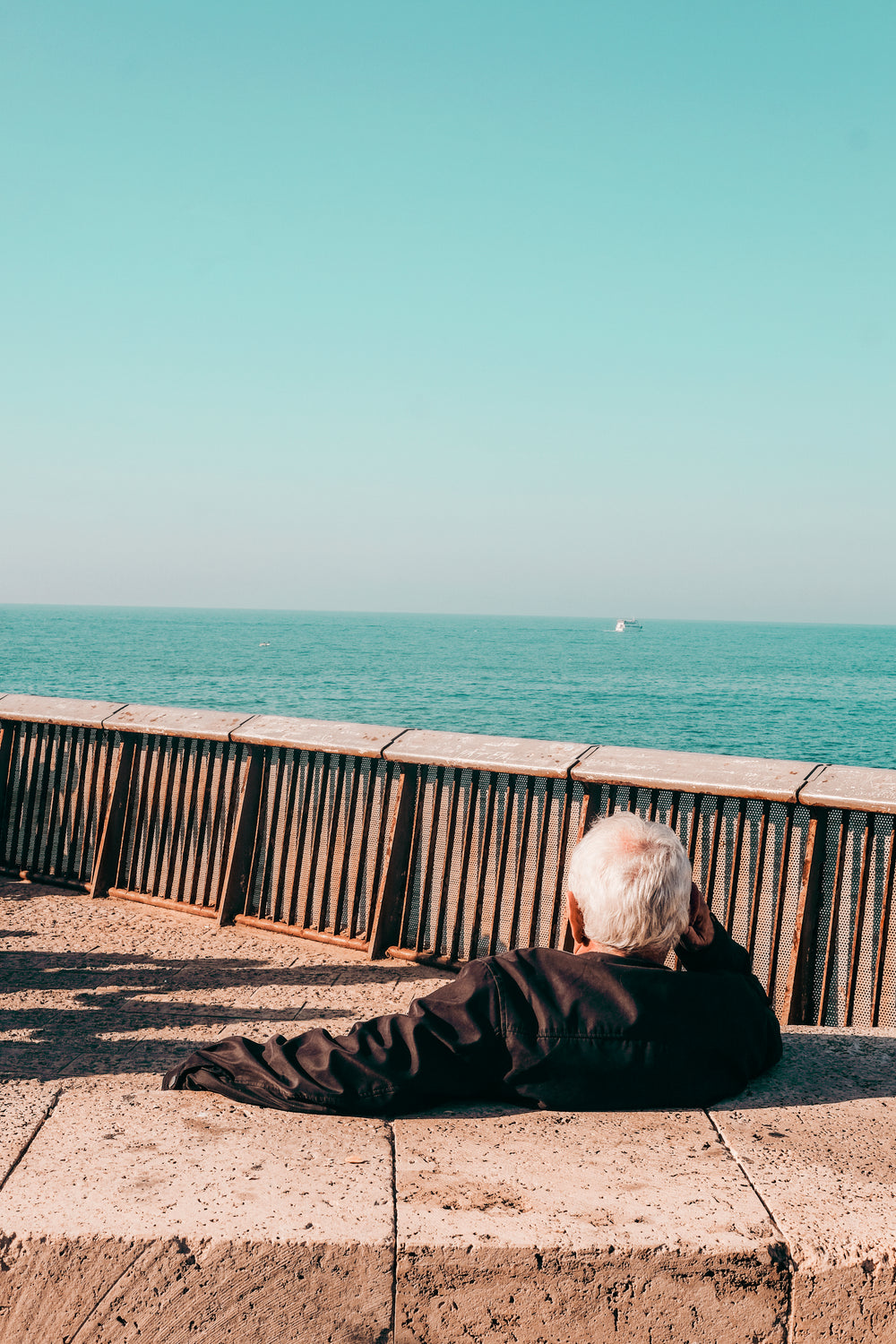 person relaxes while taking in ocean view