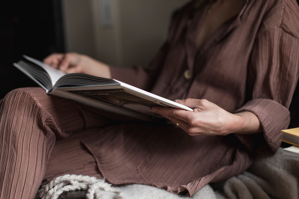 person relaxing reading a large coffee table book