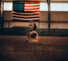 person rides a horse around a sharp turn indoors