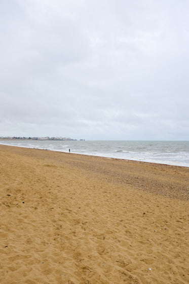 person runs on the sandy beach on a overcast day