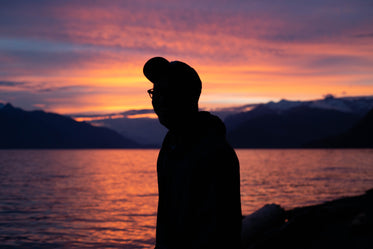 person silhouette looking at a sunset