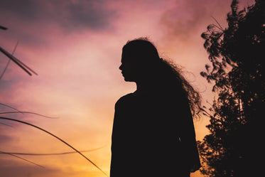 person silhouetted against a yellow and pink sky