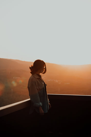 person silhouetted by warm light of the setting sun