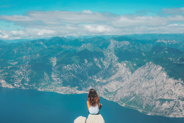 person sits and takes in the rocky mountain view