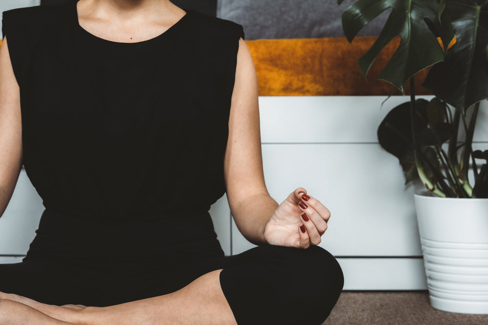 person sits cross legged in a meditation pose