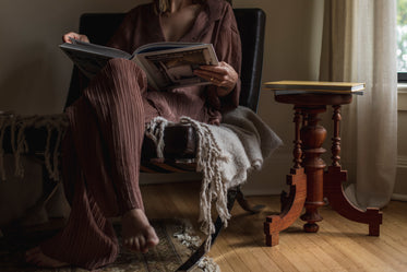 person sits in a room and reads a book