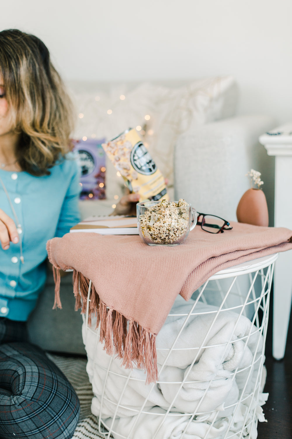 person sits in living room around blankets with snacks