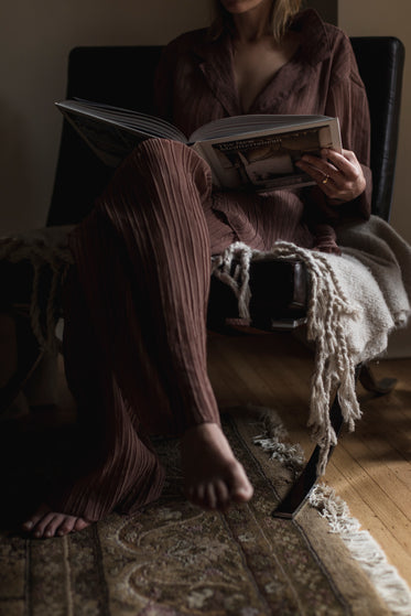 person sits reading a large coffee book