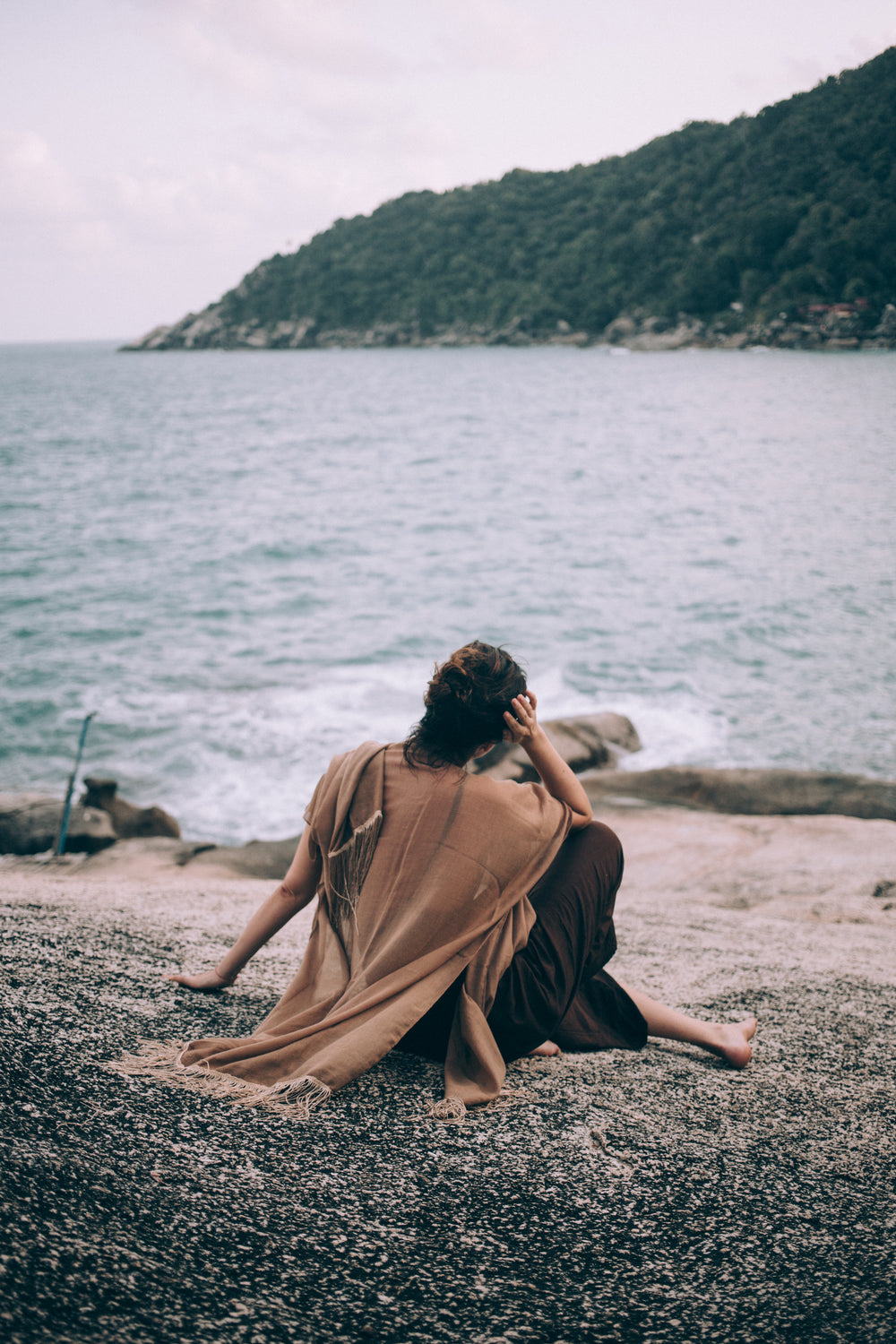 person sitting on beach looking out