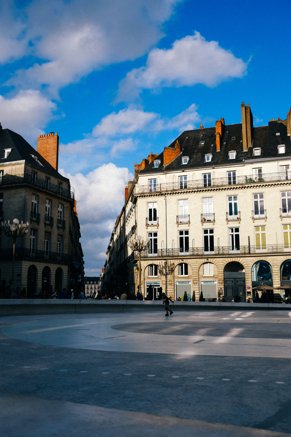 person skates through town square lined with buildings