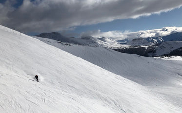 person skiing down the snow covered mountain