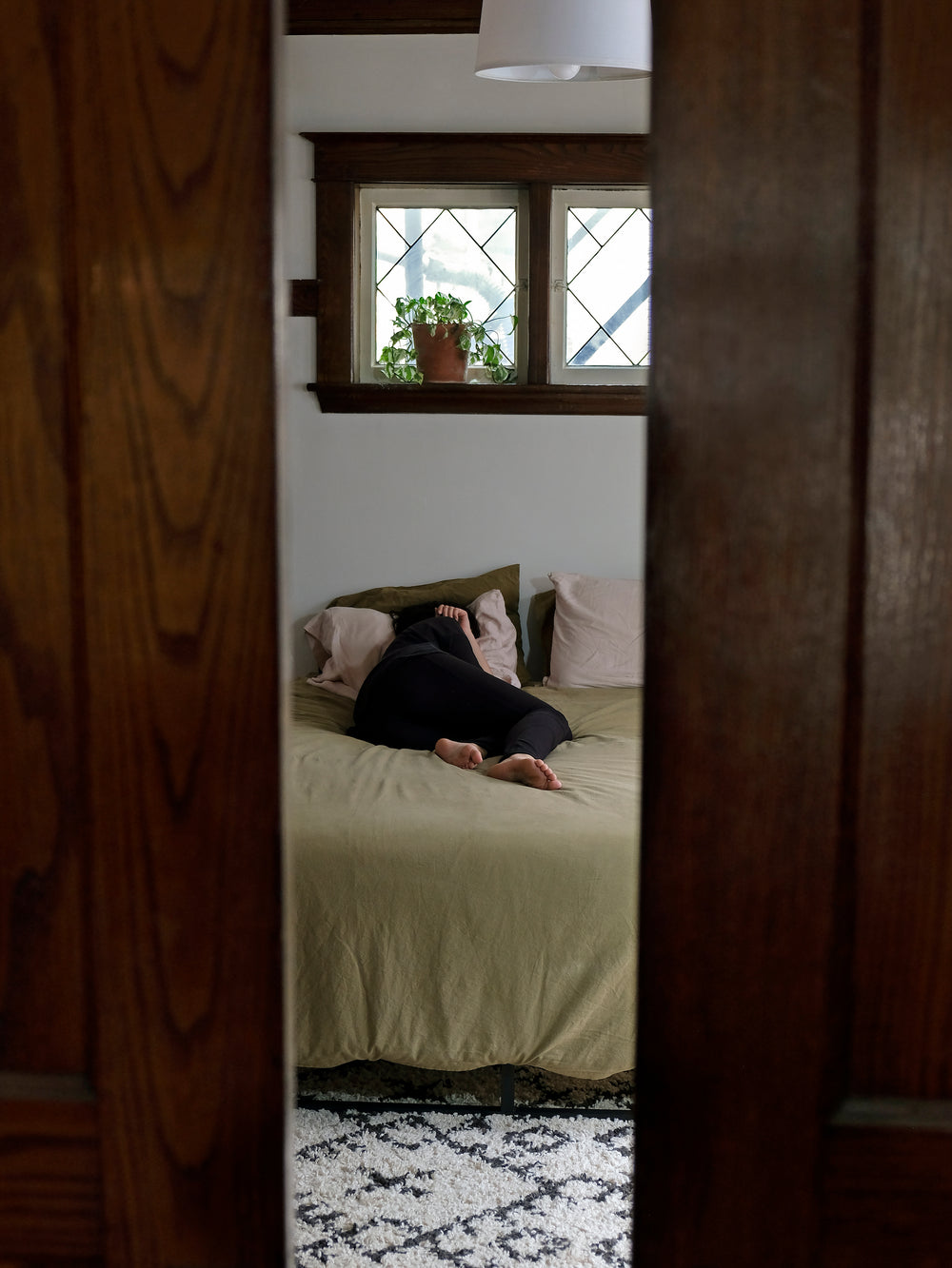 person sleeping in bed viewed between open doors