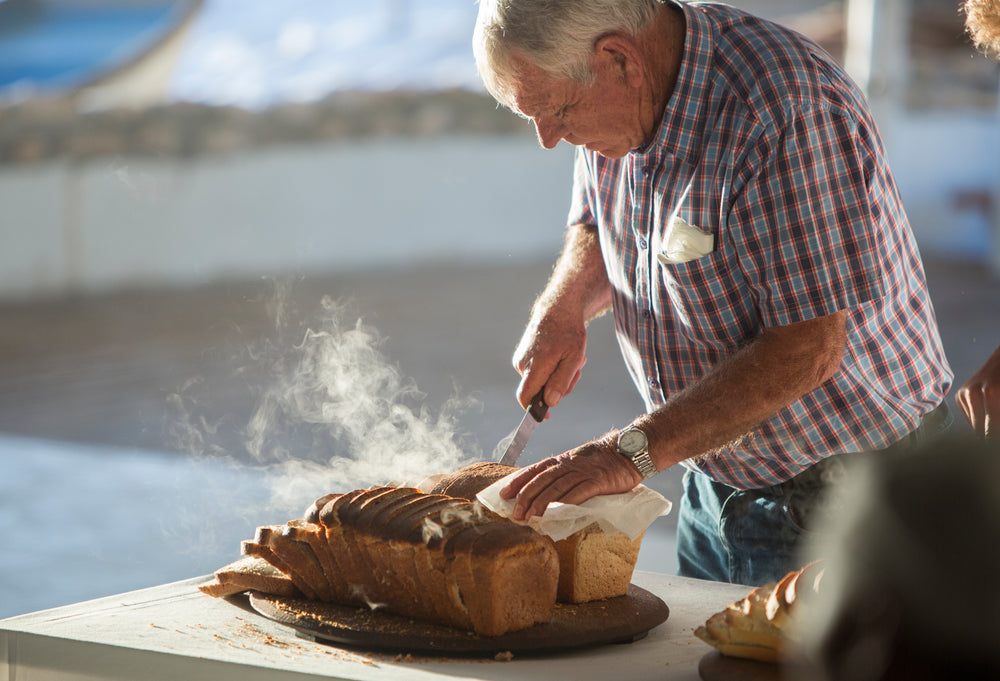 person slicing into fresh bread