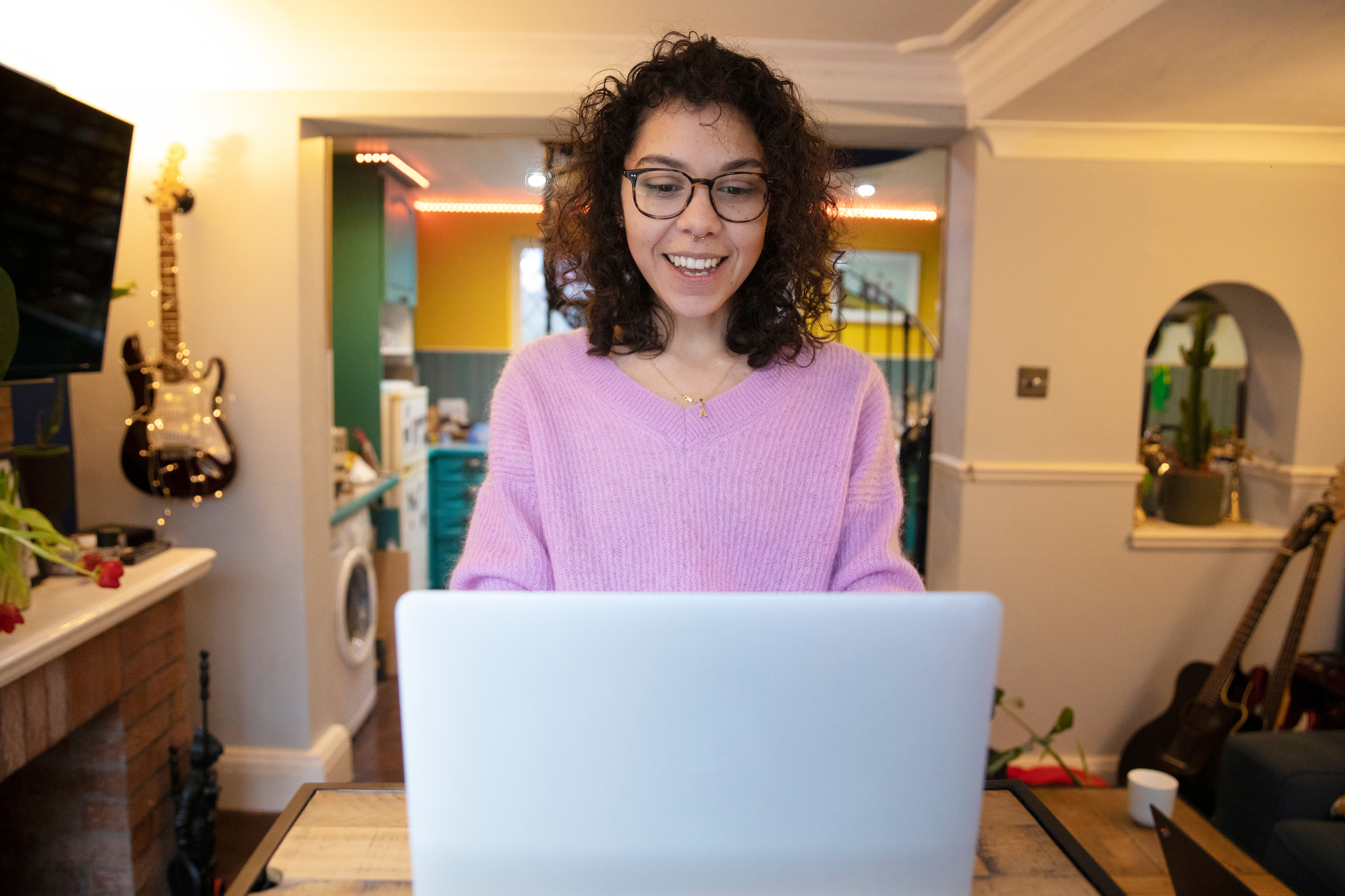 Person Smiles And Looks Down At Their Laptop