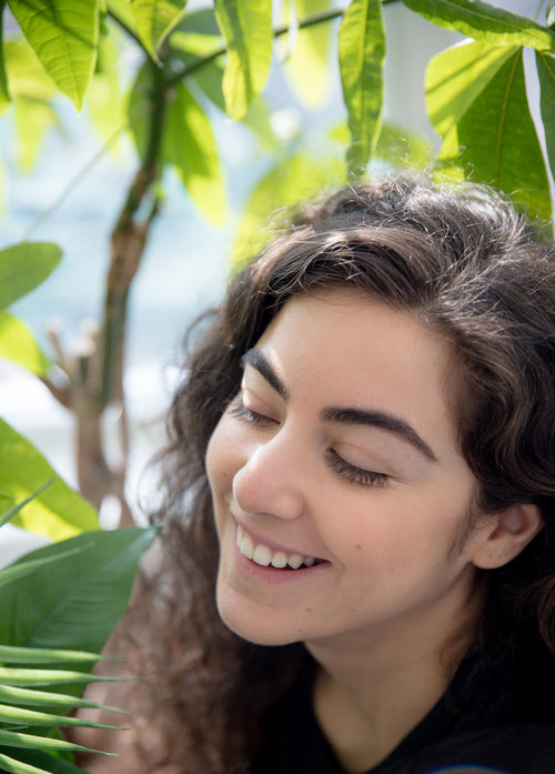 person smiling while looking at plants