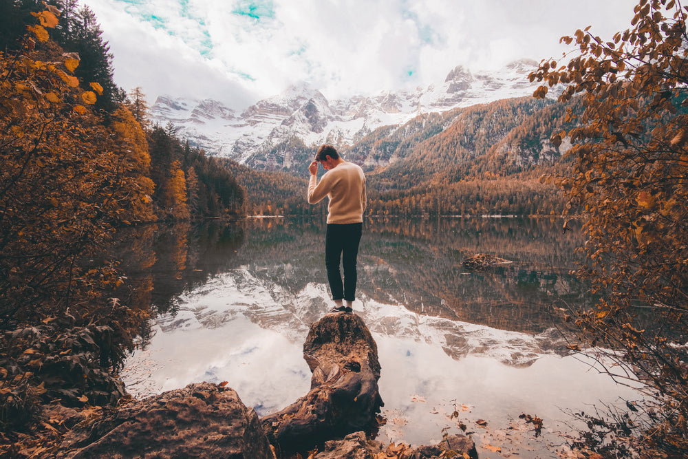person surrounded by fall colors and snowcapped mountains