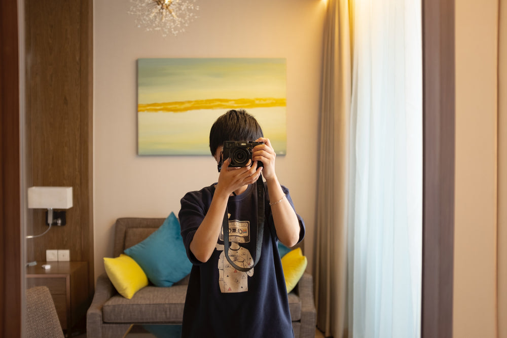 person takes a photo in their living room mirror