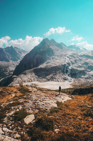 person takes in a waterfall in the mountains