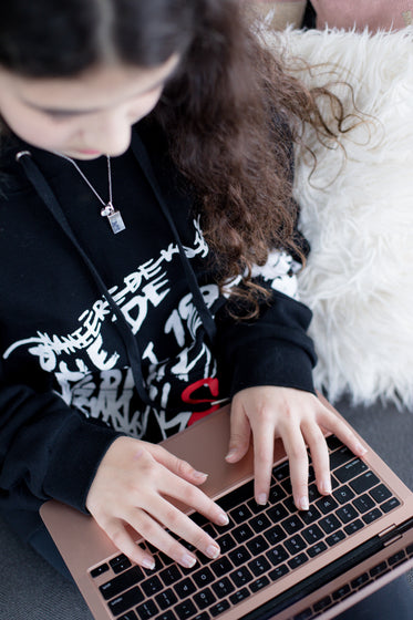 person typing on a laptop viewed from overhead