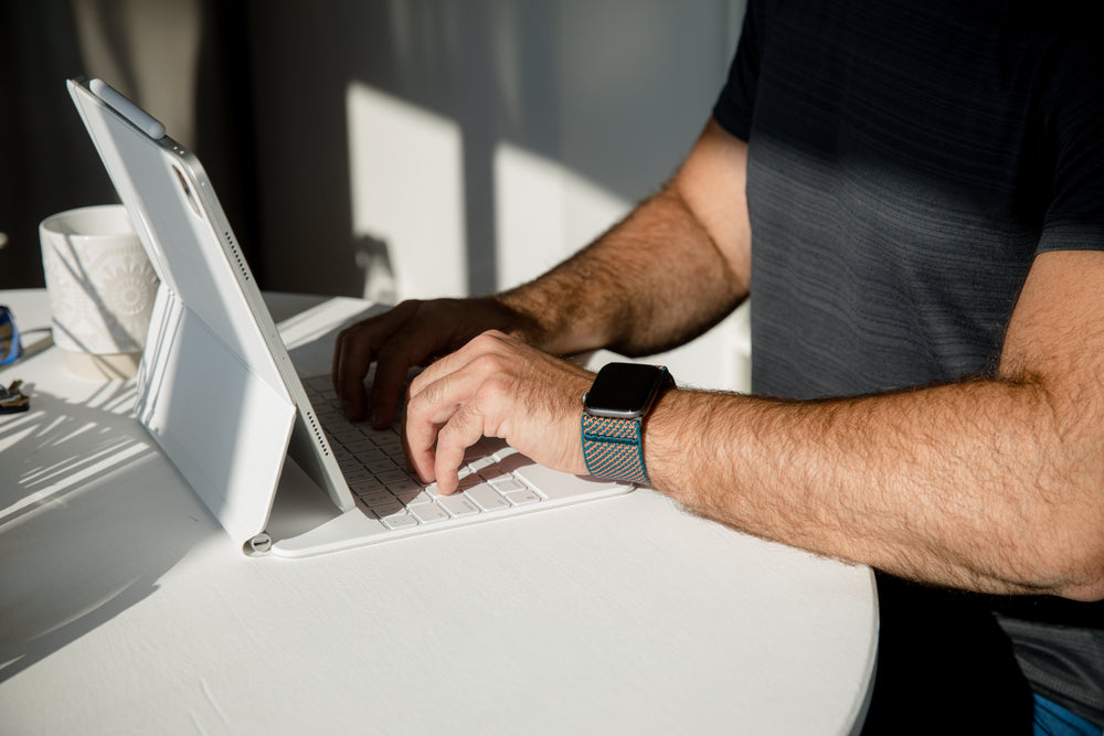 person typing while wearing a smartwatch