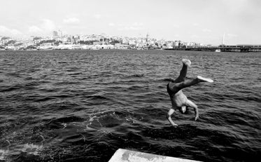 person upside down diving into water