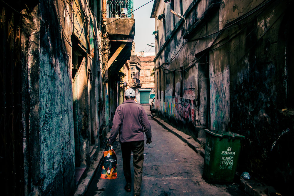 person walking along a graffiti covered alley