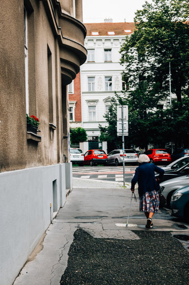 person walking down sidewalk with a cane