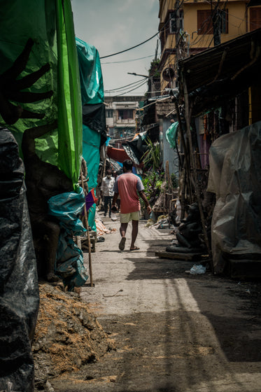 person walks down a narrow covered alleyway