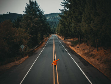 person walks down a paved country road