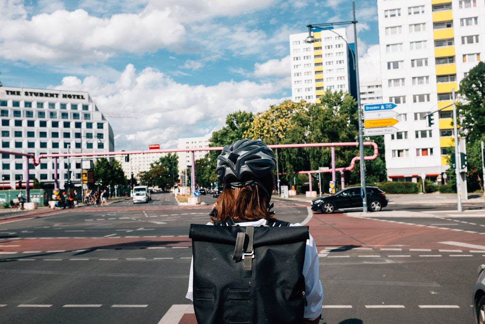 person with black helmet waits their turn in city intersection