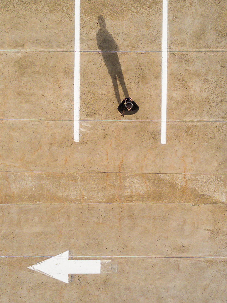 Person With Long Shadow In Parking Spot