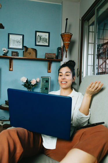 person works from their couch talking to laptop screen