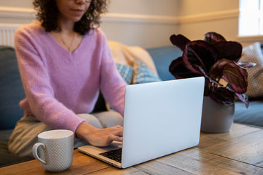 person works on their laptop from couch