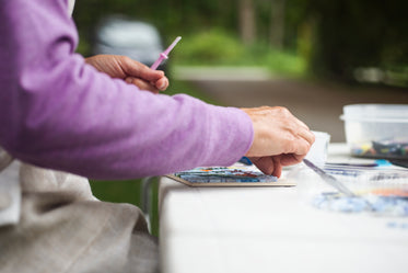 person works on their mosaic outdoors