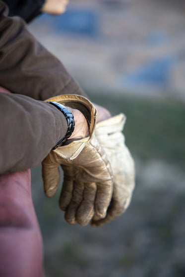 persons hands wearing dirty white gloves